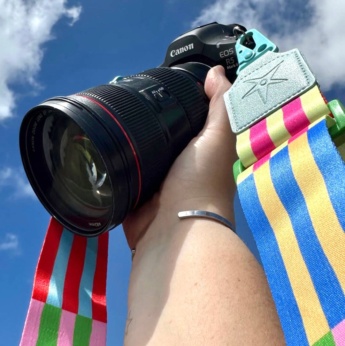 Lifestyle image of RAINBOW ROAD striped Strappi strap styled with a handbag